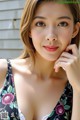 A woman in a floral dress posing for a picture.