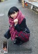 A woman in a school uniform is posing for a magazine.